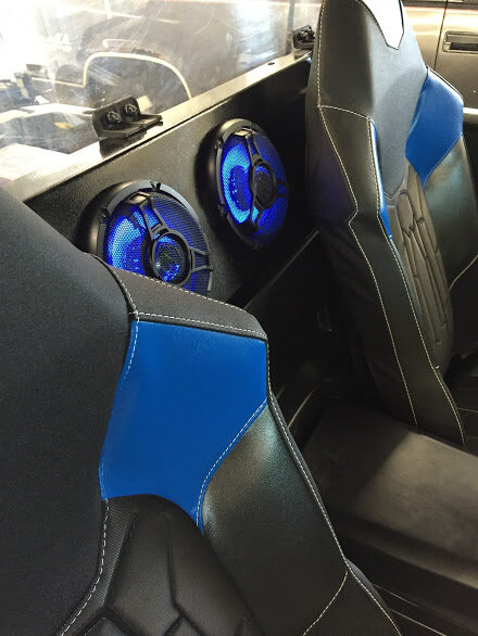 Illuminated speakers mounted behind the seats of a side by side UTV