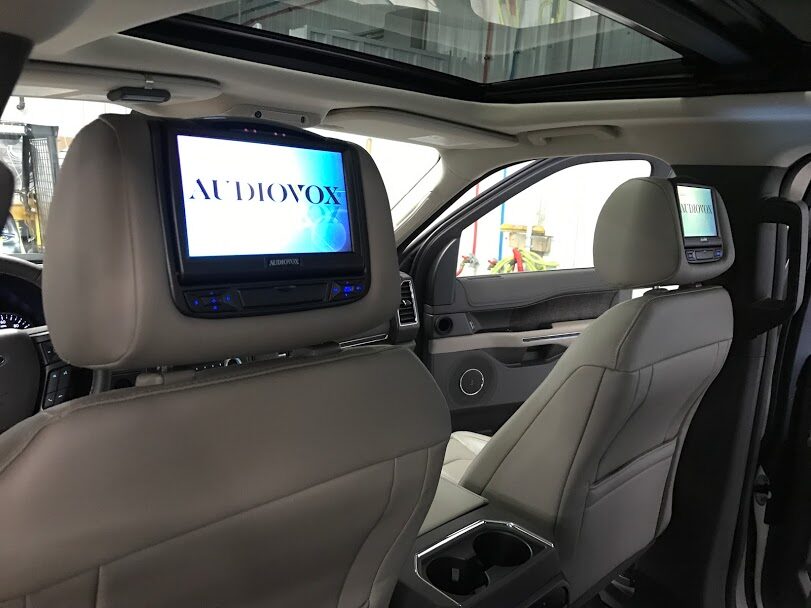 Headrest entertainment screens installed in the rear seats of an SUV