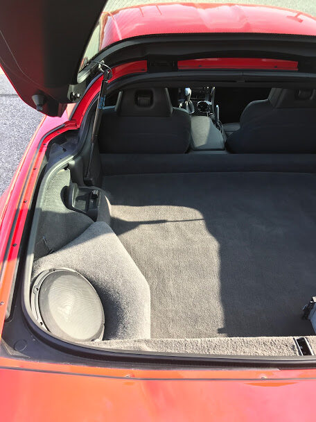 Factory style subwoofer enclosure fitted into a sports car cargo area
