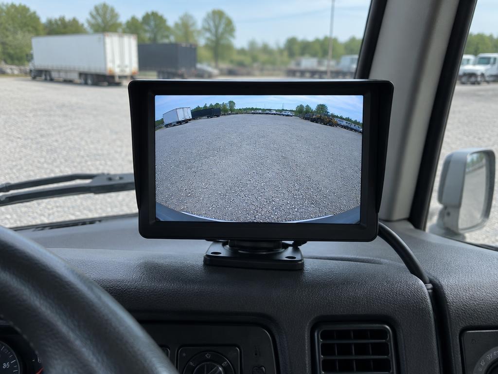 Backup camera monitor mounted on a truck dash showing the rear view