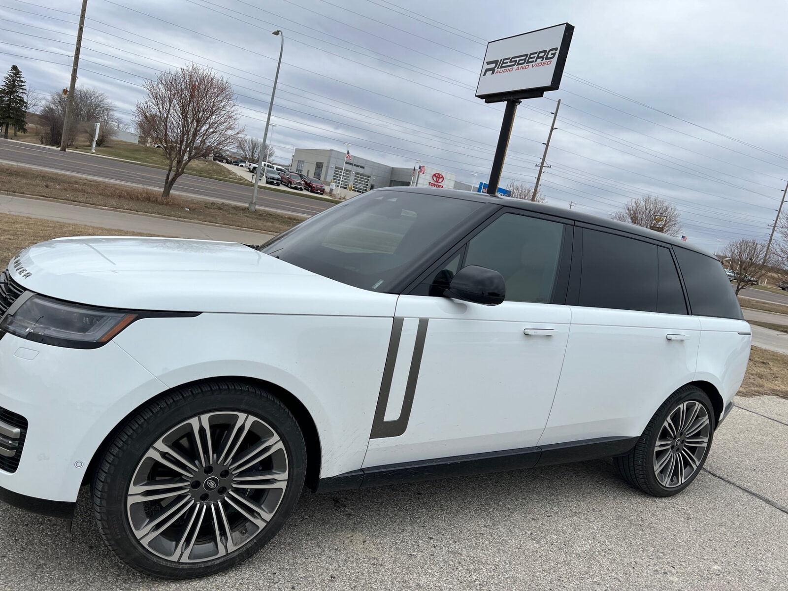 White SUV with freshly installed window tint parked outside the shop in Carroll Iowa