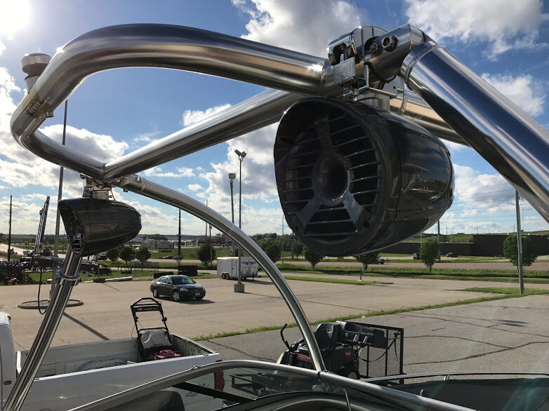 Marine speaker pods mounted on a polished wakeboard tower above a boat