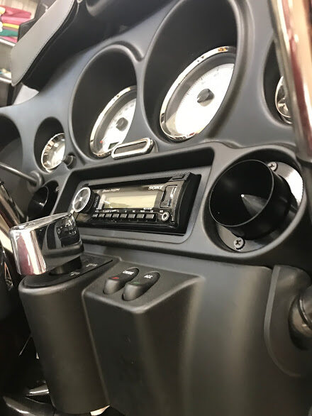 Motorcycle fairing with an aftermarket stereo and speaker installed in the dash