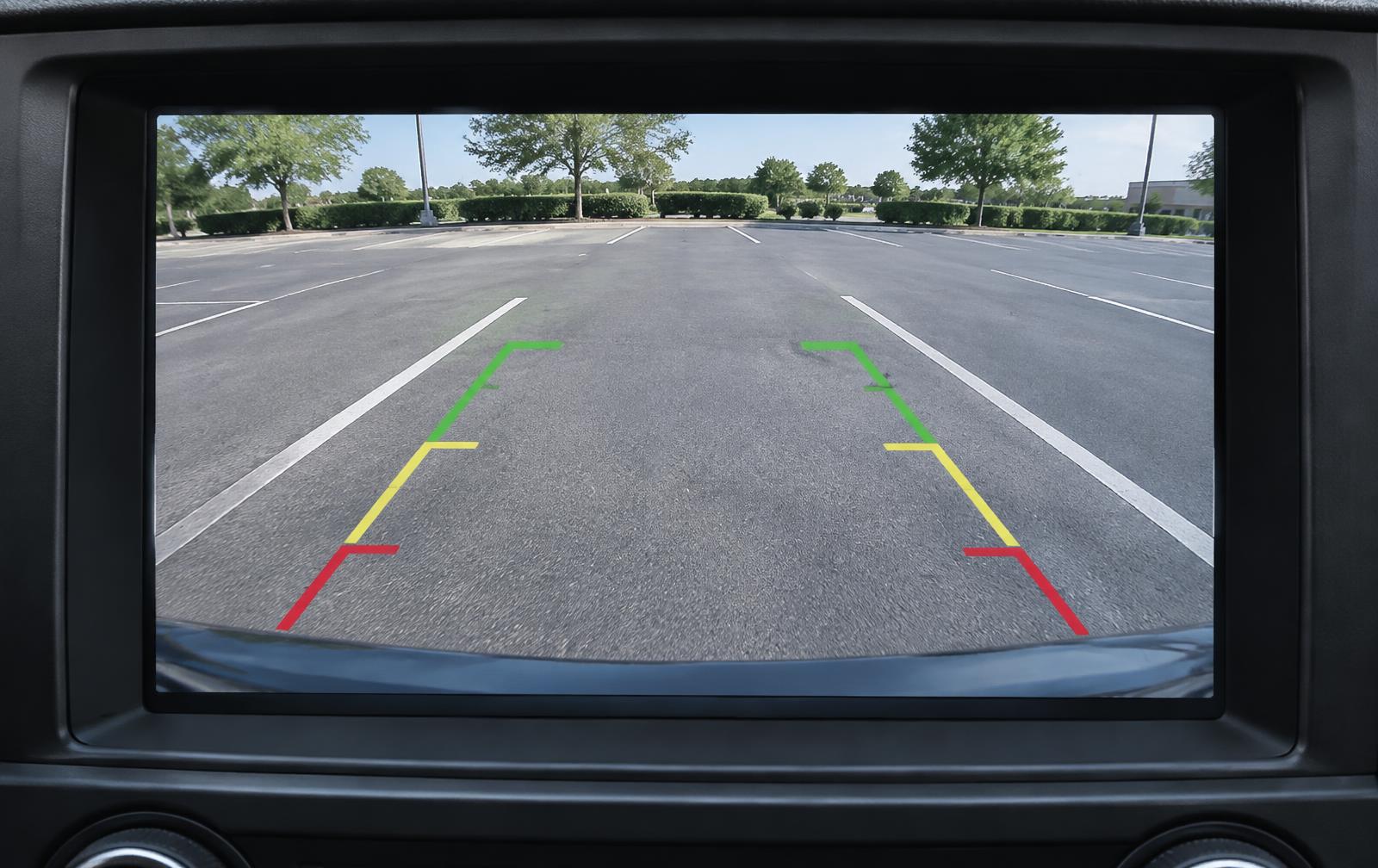 Backup camera view displayed on a vehicle dashboard monitor while parking